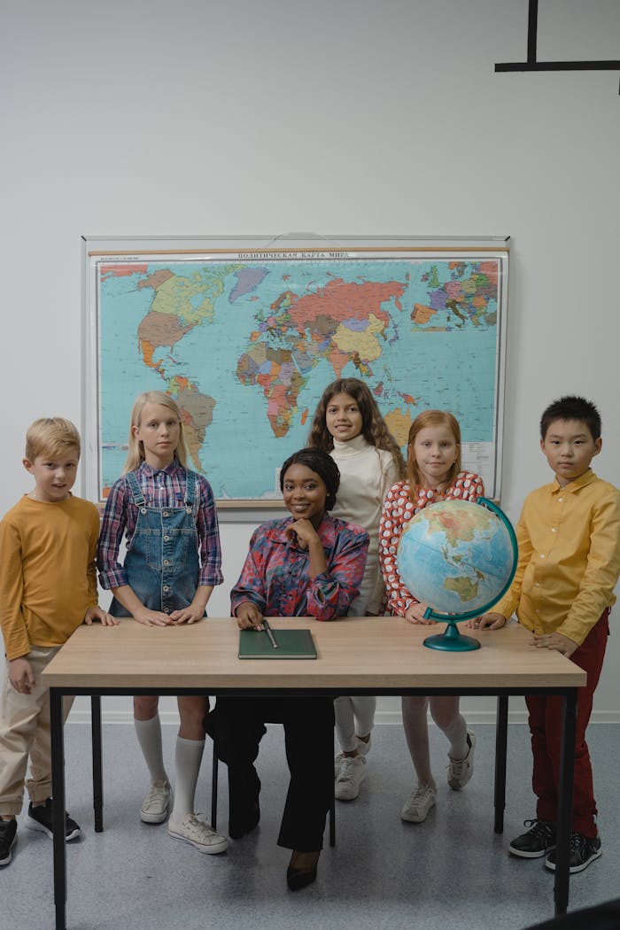 Children learning geography in an elementary classroom with a globe and world map.