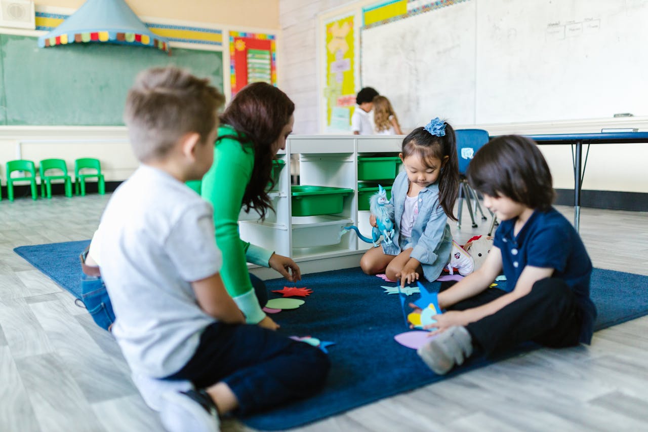 Kids and teacher in a kindergarten classroom engaging in creative play on the carpet.